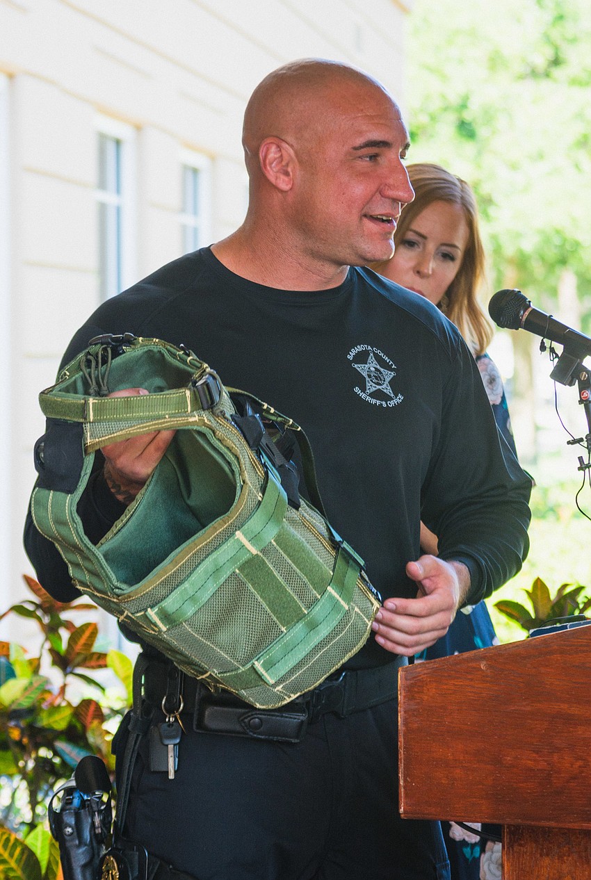 Deputy Troy Sass, supervisor of the K-9 Unit, shows off one of the new vests and explains its features.