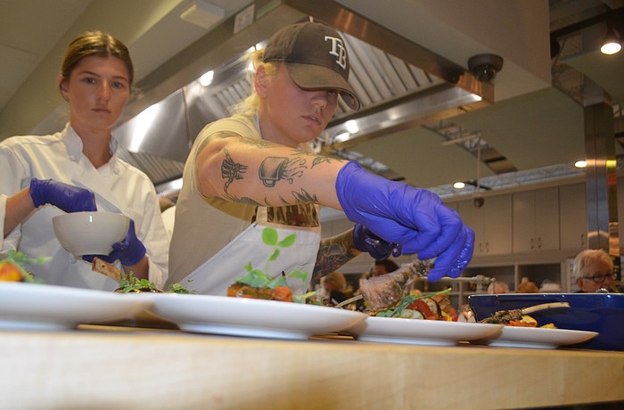 Katy Peterson places the lamb on the plate before it is served.