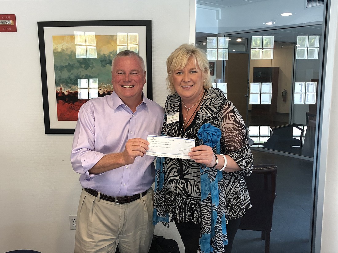 Longboat Key Kiwanis Club member Jack Brill awards a $1,000 grant to CEO Maribeth Phillips of Manatee Meals On Wheels.