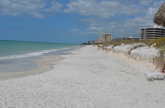 Beachgoers have no recreational beach to walk on behind Lâ€™Ambiance at high tide.