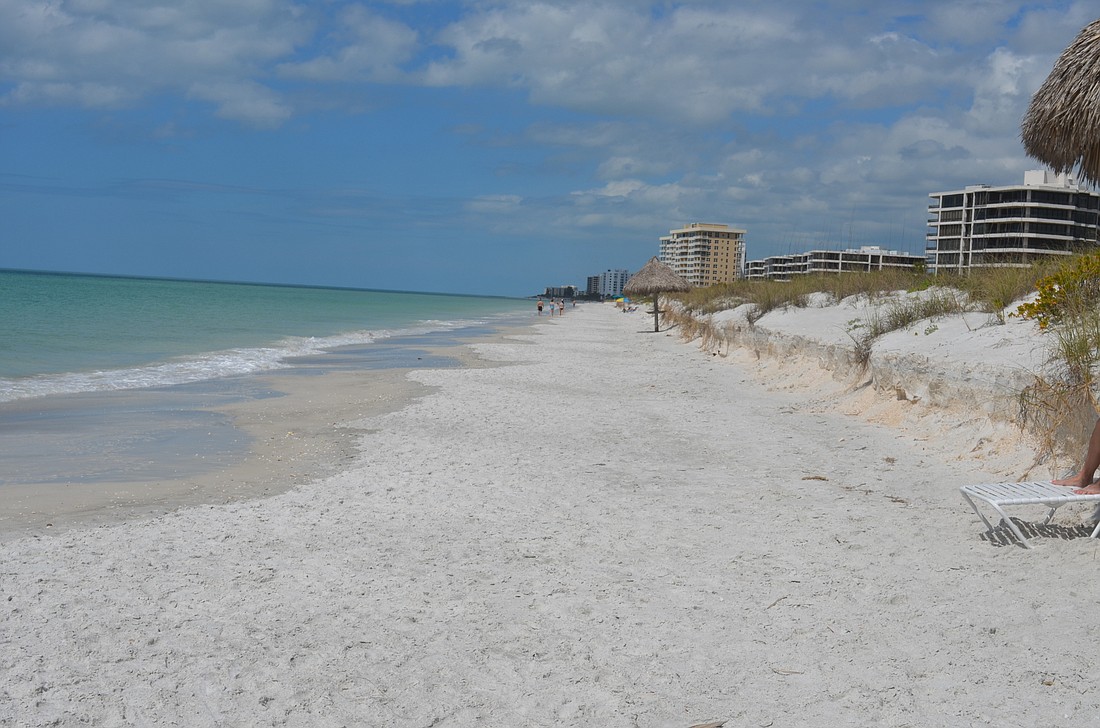 Beachgoers have no recreational beach to walk on behind Lâ€™Ambiance at high tide.