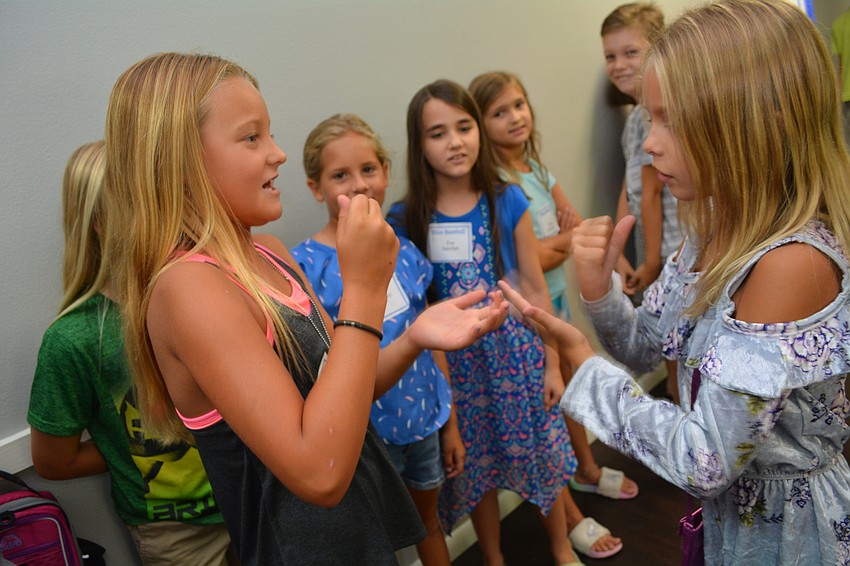 Nine-year-old Amari Rasch and 8-year-old Juliette Butler play handshake Tic-Tac-Toe.