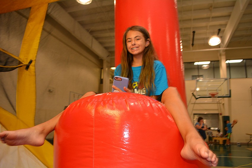 Upcoming Braden River Middle School sixth-grader Haylee Hogan helps manage children on an inflatable obstacle course. She volunteered on the youth-led worship team for VBS.