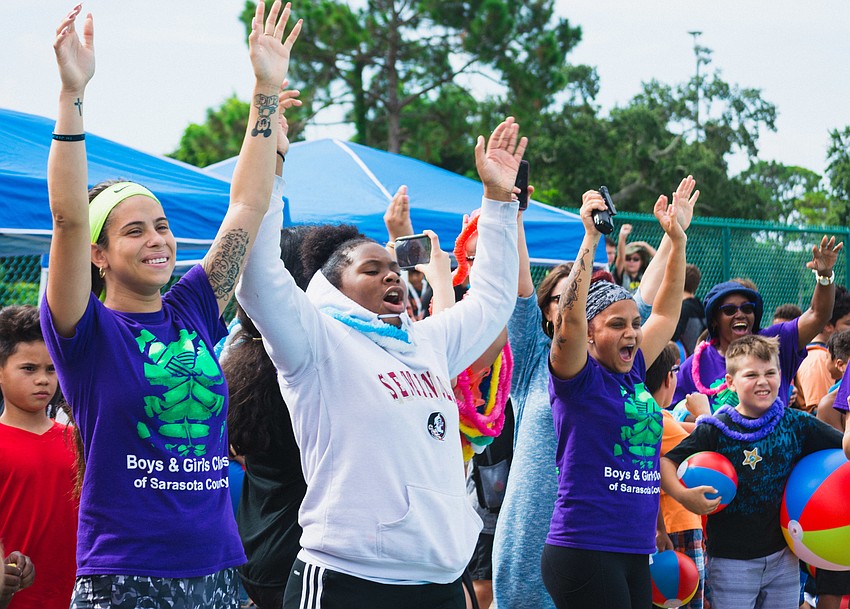 Members of the Boys and Girls Club cheer on their favorite boats.