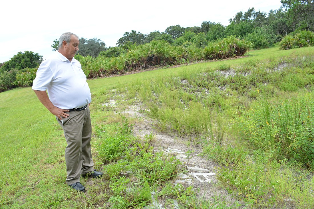 Inter-District Authority Landscape Supervisor Rob Campbell points to a steep drop-off along the riverbank where concrete mat is supposed to prevent erosion. The grant would reestablish this area behind Greenbrook Adventure Park.