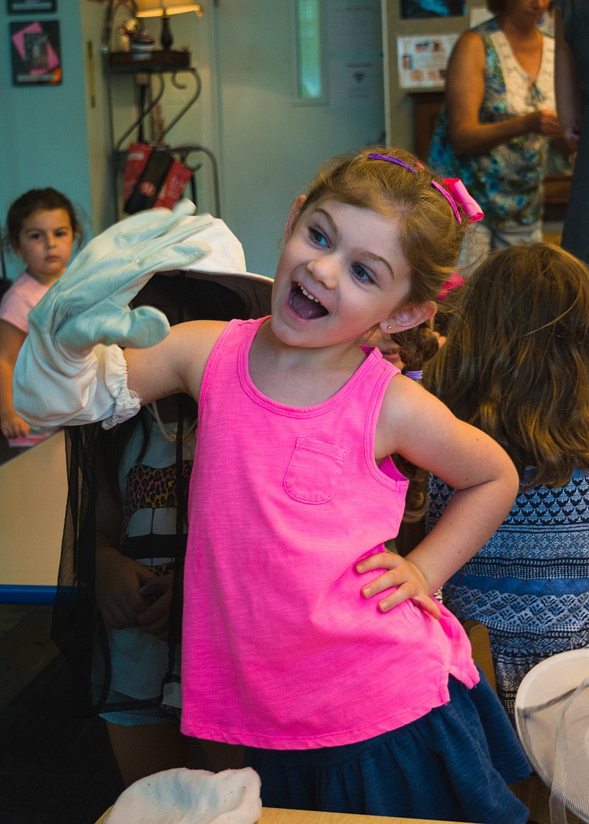 Elliot Hollen tries on a protective beekeeping glove.