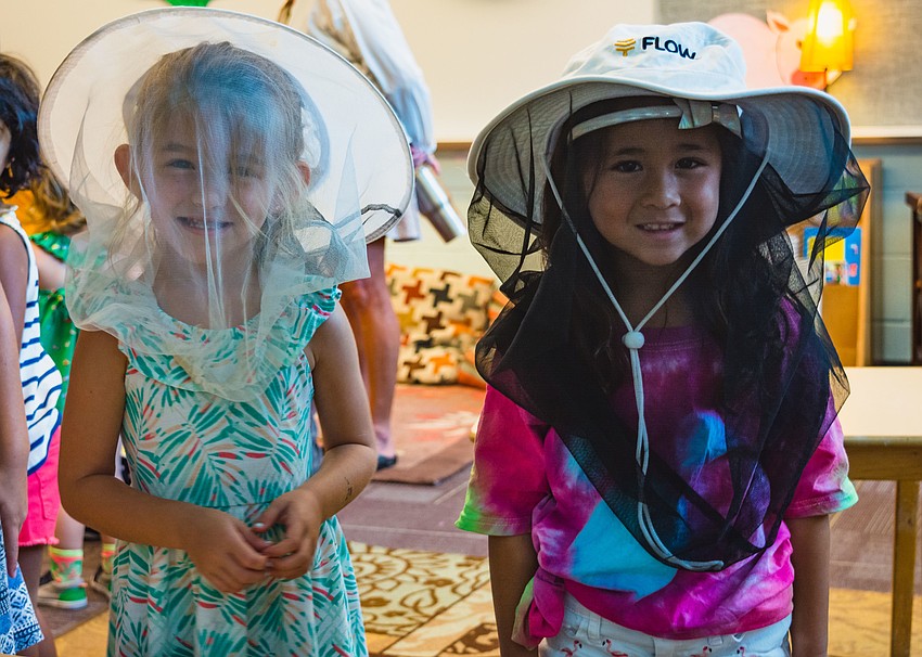 Annabelle Taplinger and Sophie Lirio try on protective hats that are worn by beekeepers.