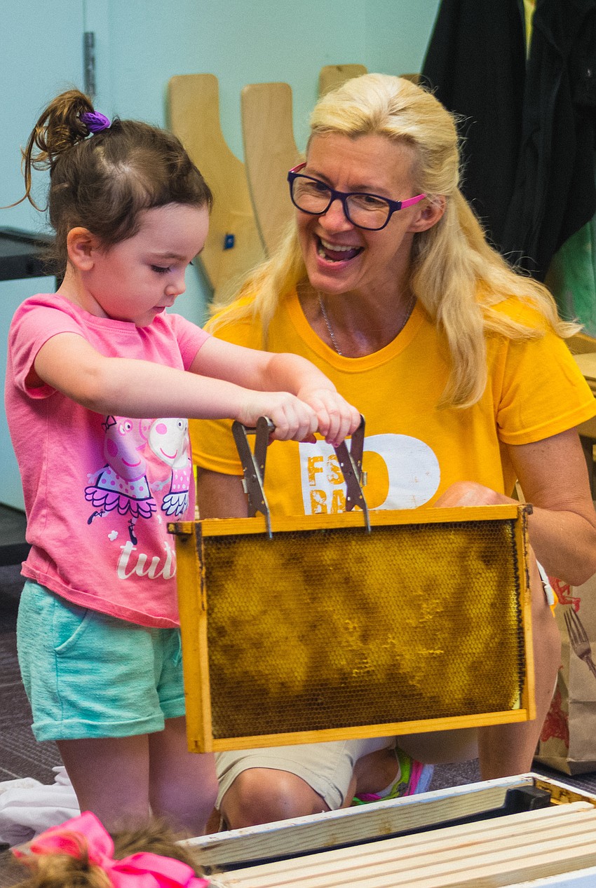 Eva Hakim tries her hand and pulling out a hive frame.