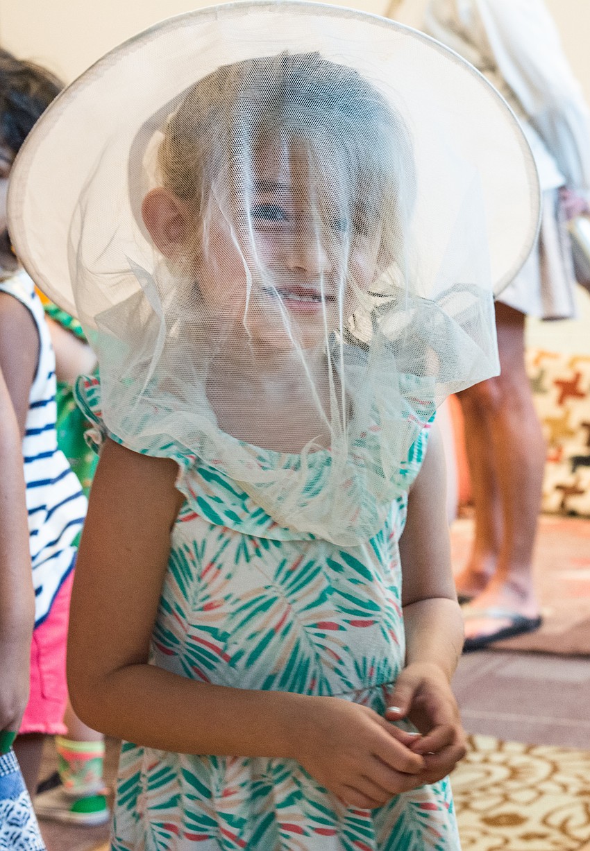 Annabelle Taplinger tries on a protective hat worn by beekeepers.