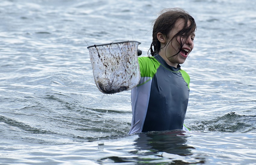 Elliott Benson is all smiles as he shows his friends what he found while skimming Sarasota Bay.