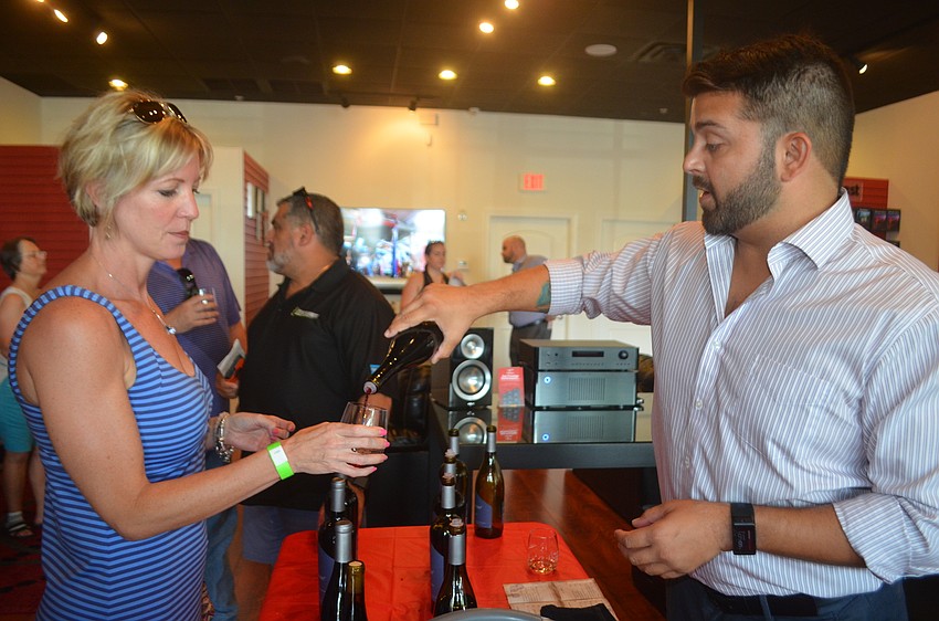 Sarasota's Karie Backman listens to wine expert Erik Anderson during her stop at Integrity Sound.