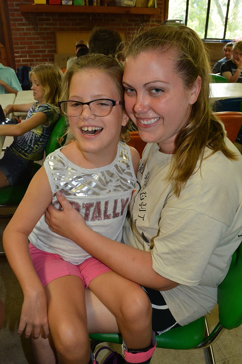 Nine-year-old Kiley Griggs snuggles with counselor Hannah MacDonald.