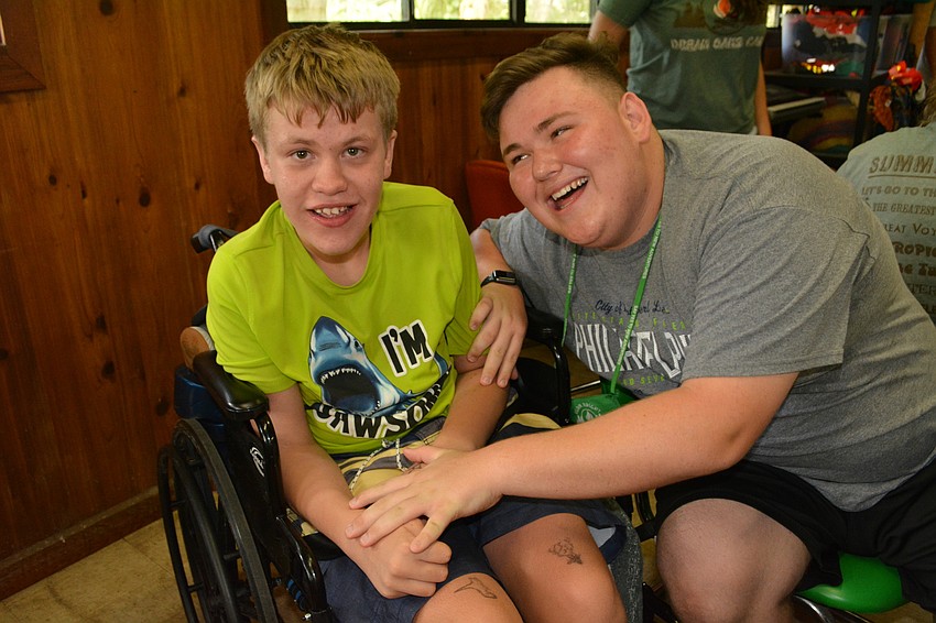 Campber Ethan Stirna, 15, is all smiles with his counselor-in-training Luke Brunner, of Braden River High School.