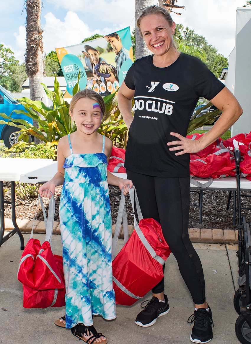 Olivia Geyer helps give out free school supplies with her mother, Danielle.