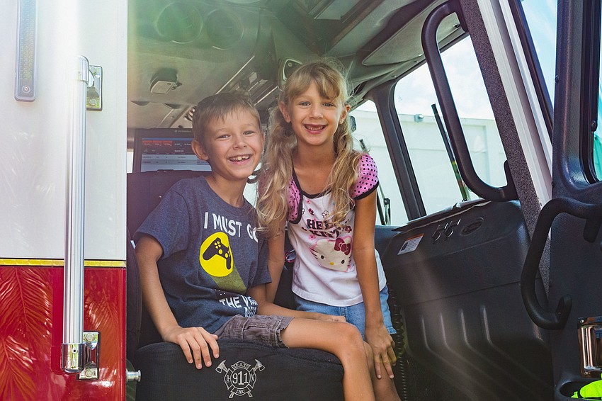Rylan and Regan Bauwin explore the inside of a fire truck.