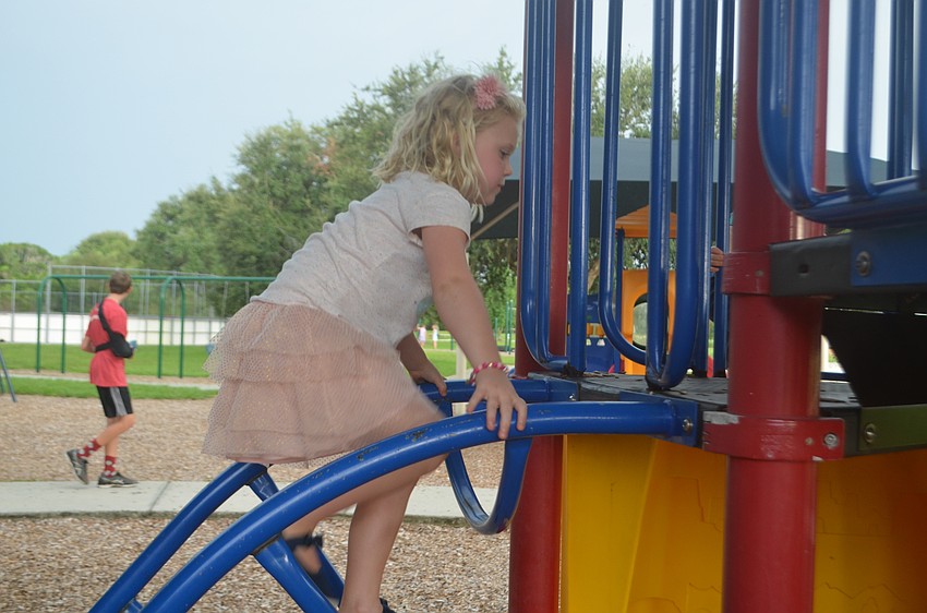 Bradenton's Harper Davenport, 6, climbs the bars on the playground to get to the slide.