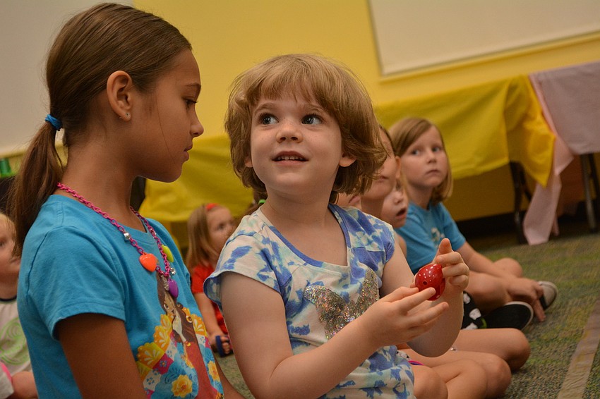 Charlotte Allen, center, makes sure to get a front row seat, where she can catch bubbles released by the genie.