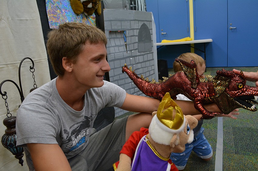 Braden River High School's Aaron Patmor shows off his dragon and king puppets to children after the show.