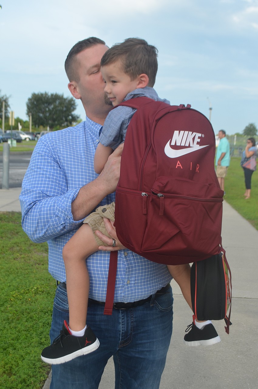 Ben Miles and gives his son Emmett, 5,  a kiss goodbye, even though it is a little bittersweet to watch him head off to kindergarten