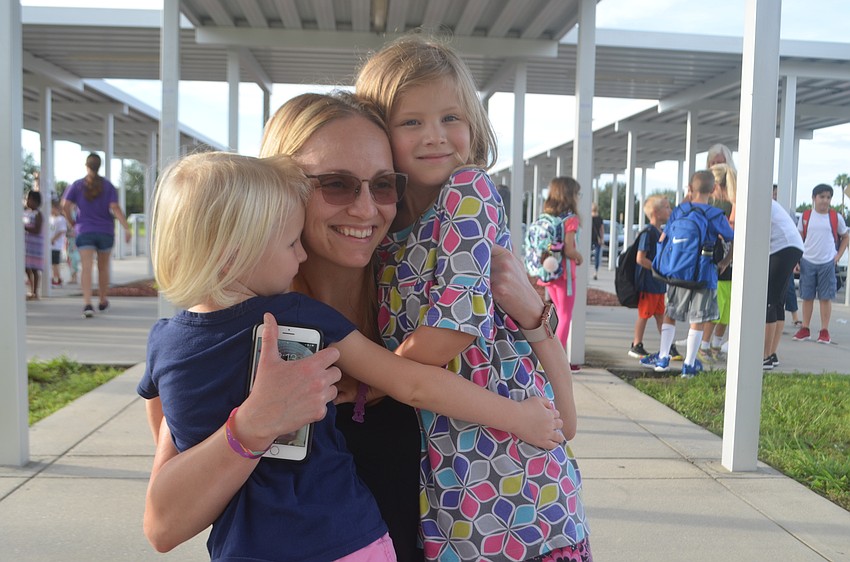 Kinga Porter hugs her two daughters, Sophia, 5, and Paige, 3, as Sophia will head off on her own at Gullett.