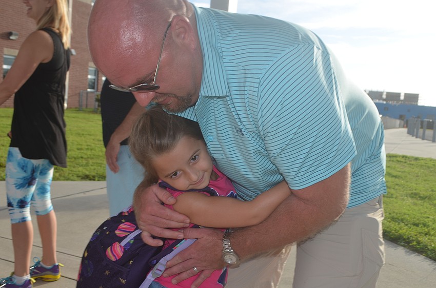 Brian Hughes gives his daughter, Anna, 5, a hug, but doesn't feel sad at all. He says that he's very happy for her, and that 