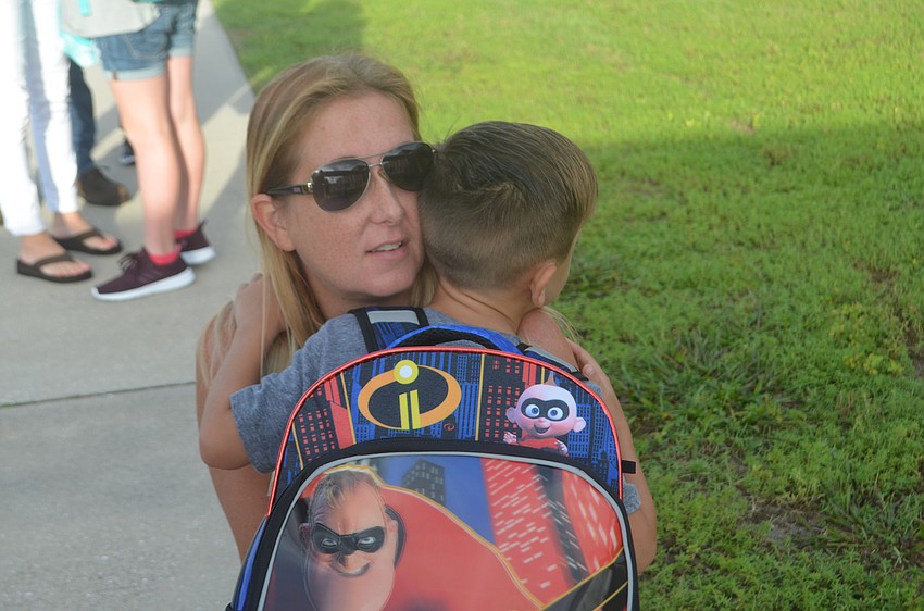 Elizabeth Pino hugs her son Julian Pino, 5, goodbye before he walks into school with his sister, Cyenna Pino, 8.