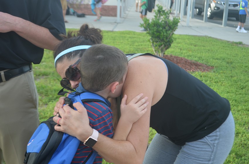 Riley Finn, 5, has trouble letting go of his mother, Beth Finn.