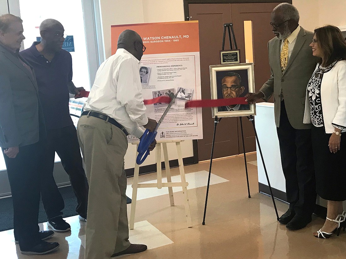 Walter Gilbert, a former patient of Dr. Chenault&#39;s, cuts the ribbon during a dedication ceremony honoring the groundbreaking doctor.