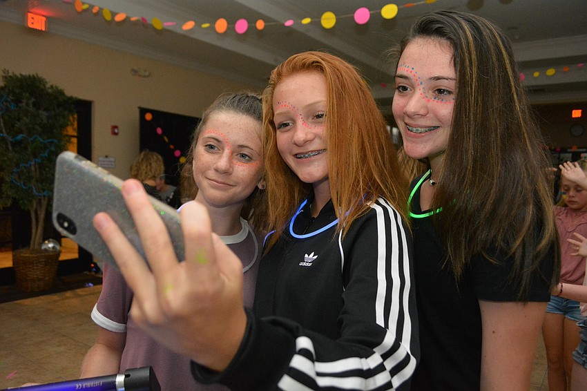 Joslyn Chapman, Leah Haynie and Sarah Diveley take a selfie of their new glow-in-the-dark face paint.