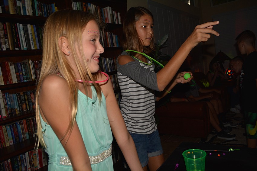 Nicole Hengel watches as her friend Emma Chapman tosses a ping pong during a game.