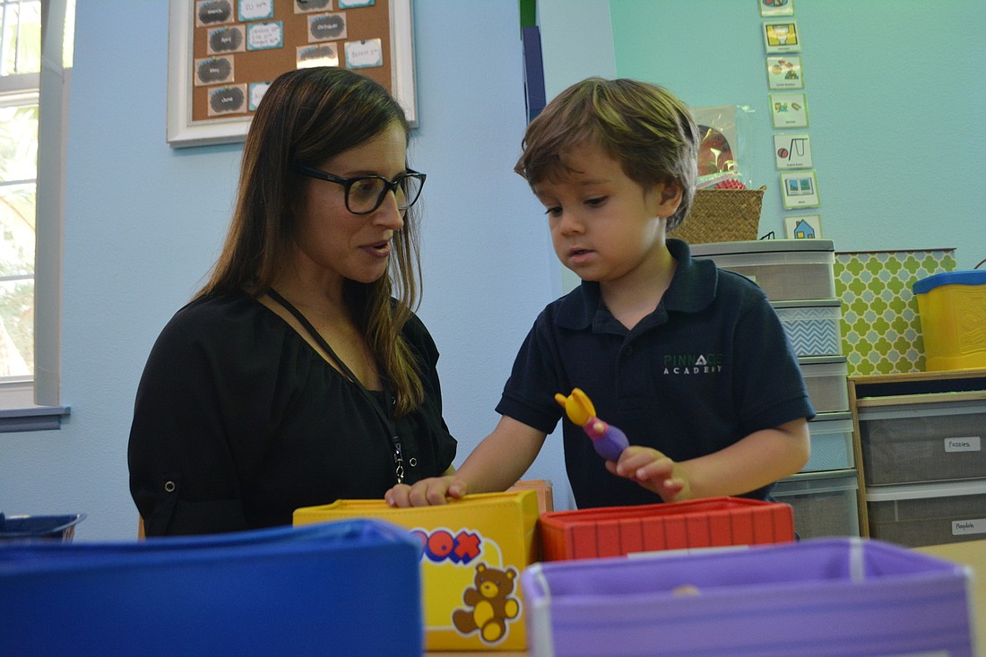 Teacher and behavioral therapist Courtney Rune works with Adam Schwab at Pinnacle Academy in Lakewood Ranch.
