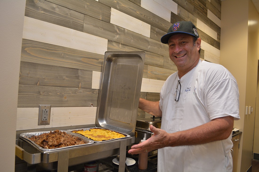 Nevin Hofing shows off his pulled pork and macaroni and cheese, which he prepared for a small private event Aug. 24 at Manatee Technical College.