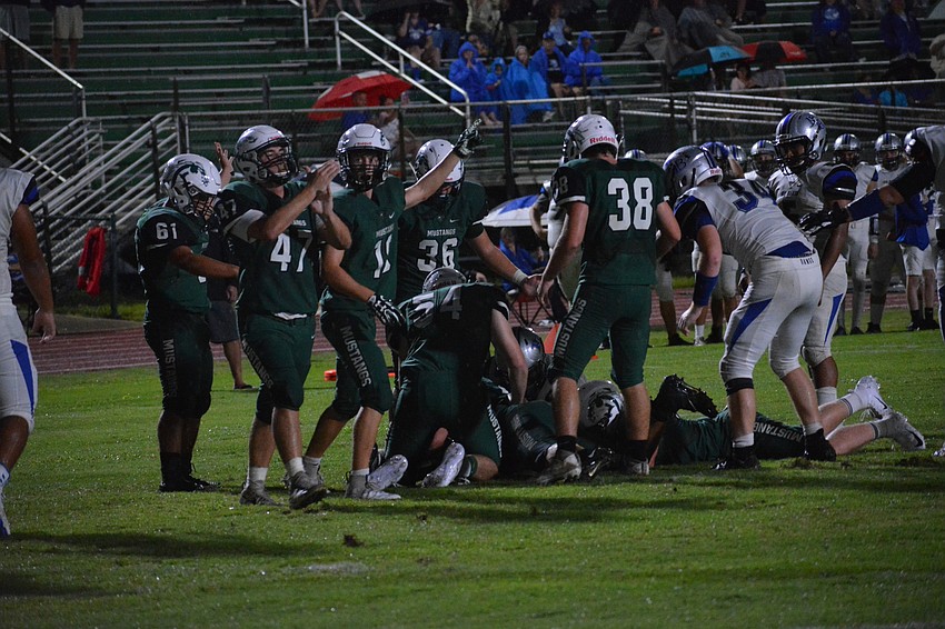Mustangs players point toward their end zone in response to recovering a fumble.