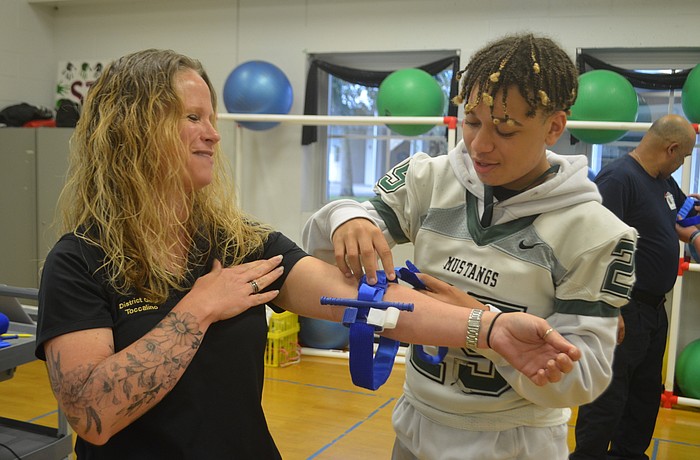 Jalen Fredericks applies the tourniquet to volunteer Shawna Toccalino.