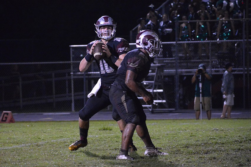 Senior quarterback Sean White looks for an open receiver while senior running back Ali Boyce looks for someone to block.