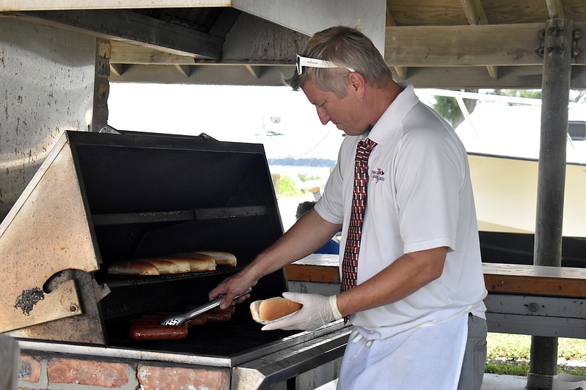 Sarasota Sailing Squadron Manager Craig Bridges grills hot dogs for members.