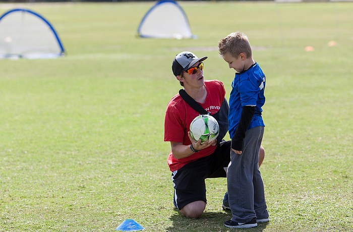 Buddy Noah Henry gives instruction to TOPSoccer player Anthony Marchione.