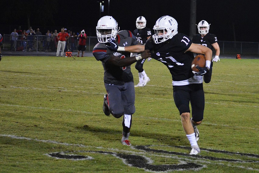 Braden River junior wide receiver Robby Goecker stiff-arms a Manatee cornerback out of his way.