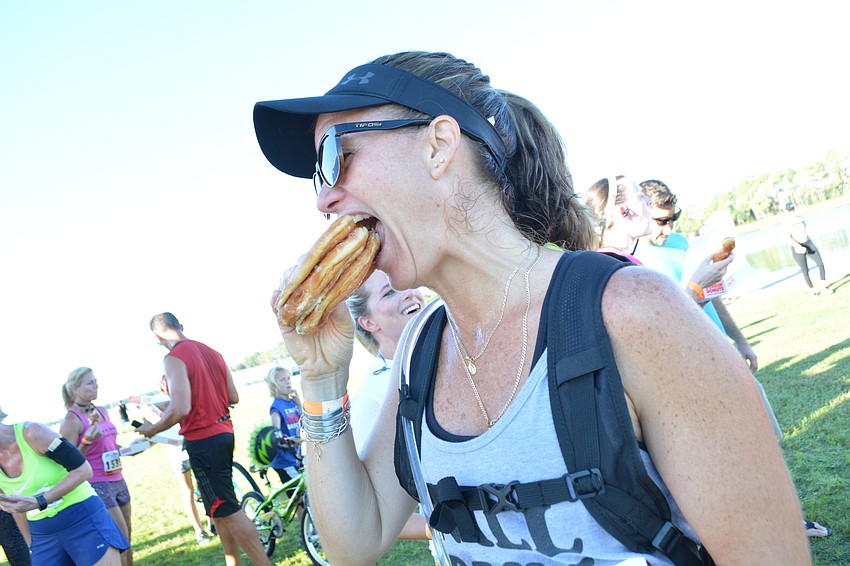 Bradenton's Kelly Petrosino squishes three doughnuts together in hopes creating one larger doughnut will go down easier. 