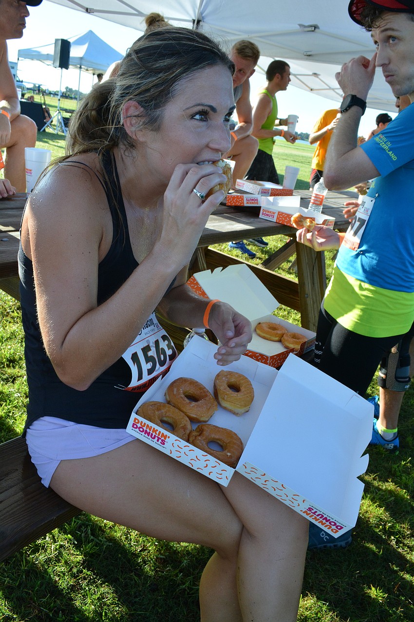 Palmer Ranch's Caitlyn McGill sits to eat her six doughnuts as her four children and husband watch with interest.