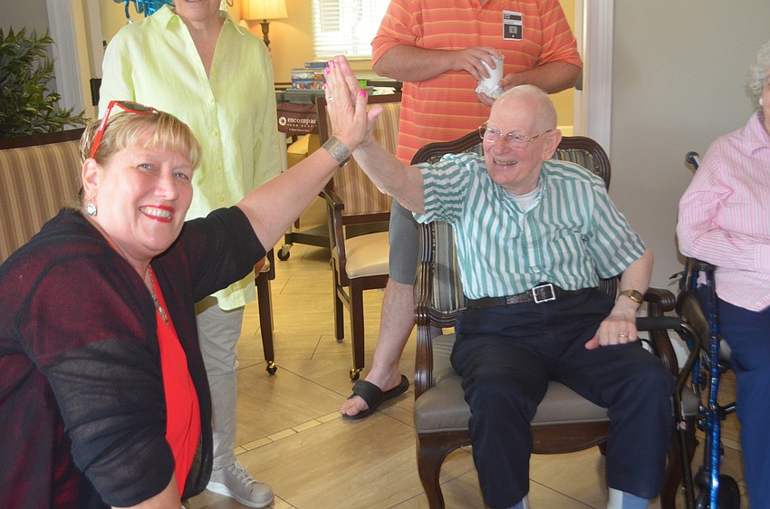 Family member and Sarasota's Deb Deam high fives her father, Bob Deam, after he wins a race, says she didn't think he would do that well.