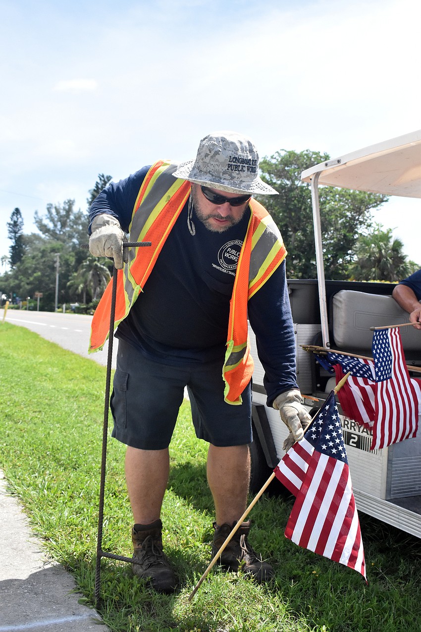 Tony Porter walks down Gulf of Mexico Drive placing an American flag about every 20 feet in honor of the 2,977 people who lost their lives on Sept. 11, 2001.