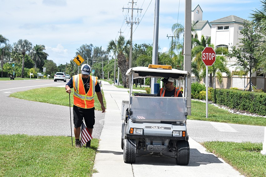 Jeremy Rodriguez and Mark Richardson, the streets, facilities, parks and recreation manager work their way down Gulf of Mexico Drive as they place flags about every 20 feet.
