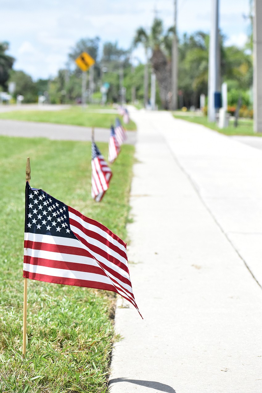 Public Works employees separated into five golf carts and placed flags along Gulf of Mexico Drive. In total, 2977 flags will be placed.