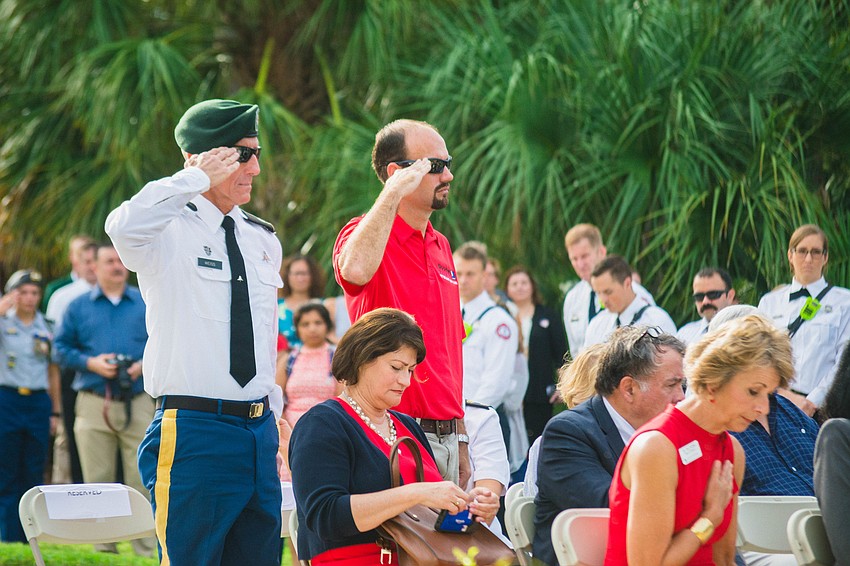 Retired Lt. Colonel and Sarasota Military Academy Senior JROTC Instructor Ben Weiss and Chris Landis stand and salute during the ceremony.