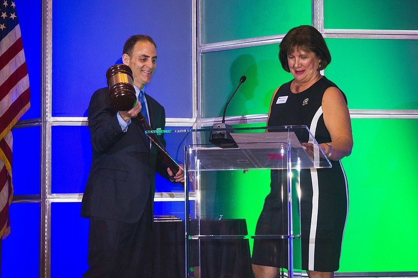 EDC of Sarasota County Chair Rae Dowling introduces Incoming Chair Larry Fineberg and passes on the giant gavel.