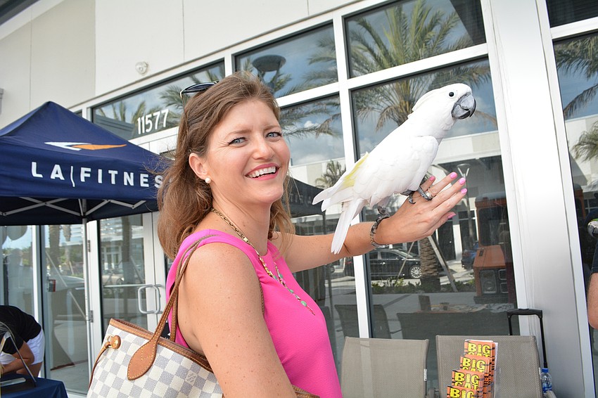 Lakewood Ranch's Mary Ewert enjoys meeting Max, an umbrella cockatoo whose visit was provided by Big Cat Habitat and Gulf Coast Sanctuary .