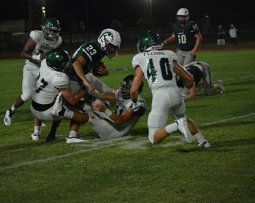 Lakewood Ranch senior running back Kieran Connolly (23) takes a run up the sideline before getting swarmed by Venice defenders.