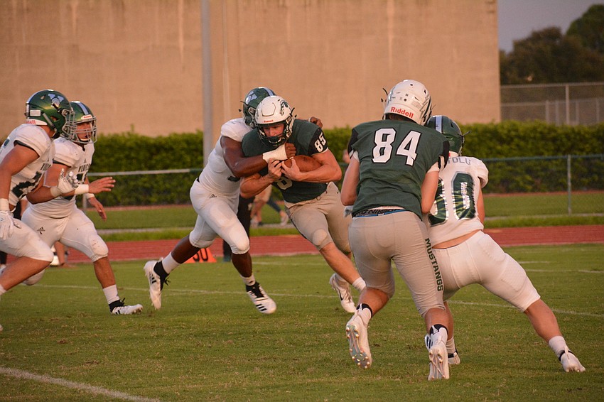 Lakewood Ranch senior Drake Theriot tries to muscle through a Venice High defender. Theriot, normally a running back, played quarterback against Venice because of injuries to the Mustangs' three typical quarterbacks.