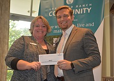 Brandi Ezell of SMART accepts a grant for $3,000 from Lakewood Ranch Community Fund President Garrett Shinn.